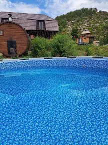 Дом из бруса с баней-бочкой и бассейном у подножия горы