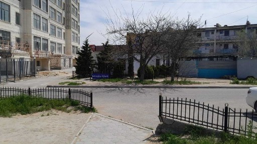 Каменное отдельно стоящее здание вдоль дороги.